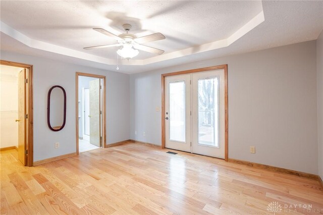 6437 Sun Ridge Dr, Waynesville, OH 45068 - unfurnished room featuring a raised ceiling, light wood finished floors, a ceiling fan, and a textured ceiling