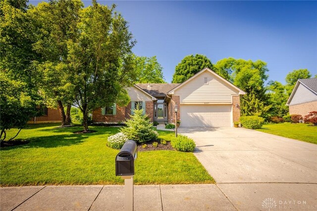 6437 Sun Ridge Dr, Waynesville, OH 45068 - view of front of house featuring an attached garage, concrete driveway, a front yard, and brick siding
