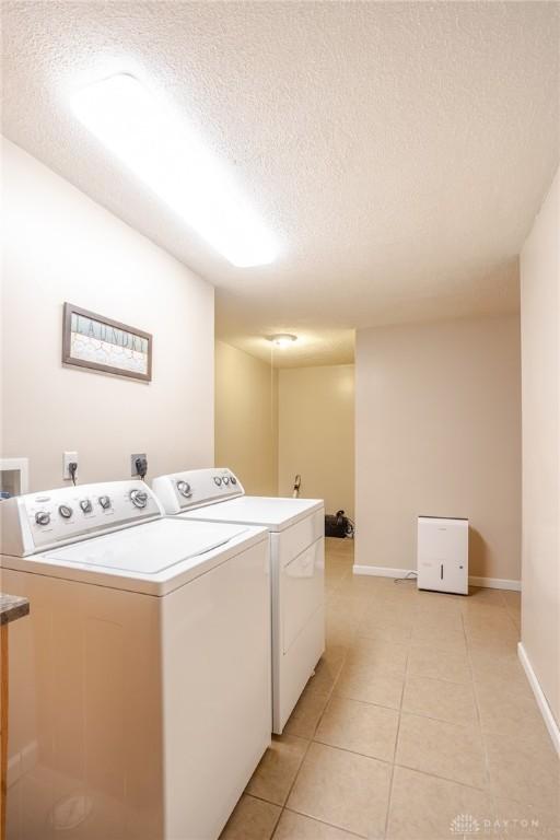 6437 Sun Ridge Dr, Waynesville, OH 45068 - laundry area with independent washer and dryer, a textured ceiling, and light tile patterned flooring