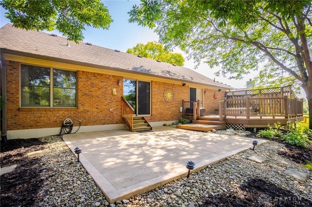6437 Sun Ridge Dr, Waynesville, OH 45068 - rear view of property with brick siding, a patio, a deck, and roof with shingles