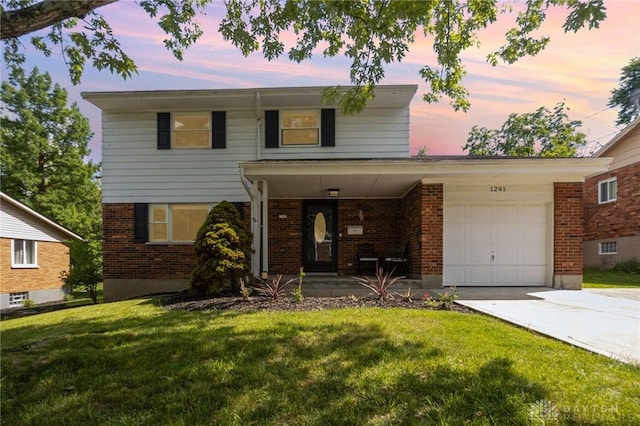 1241 Oak Knoll Dr, Cincinnati, OH 45224 - traditional-style home featuring a front lawn, driveway, a garage, brick siding, and covered porch