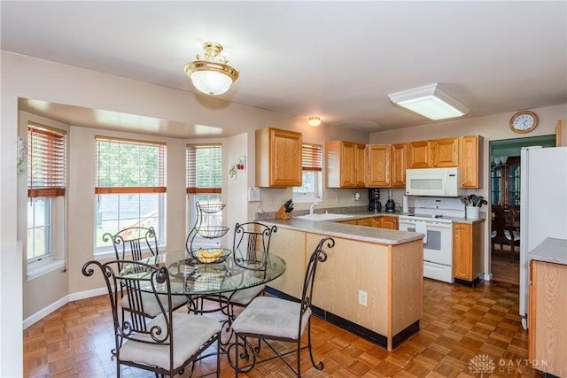 2384 Flyway Ct, Beavercreek, OH 45431 - kitchen featuring white appliances, a peninsula, healthy amount of natural light, and light countertops