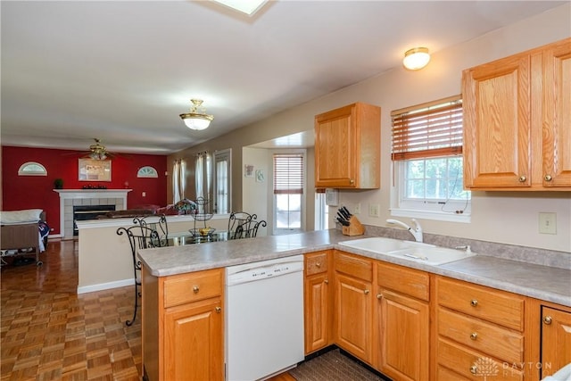 2384 Flyway Ct, Beavercreek, OH 45431 - kitchen with dishwasher, a peninsula, open floor plan, a fireplace, and light countertops