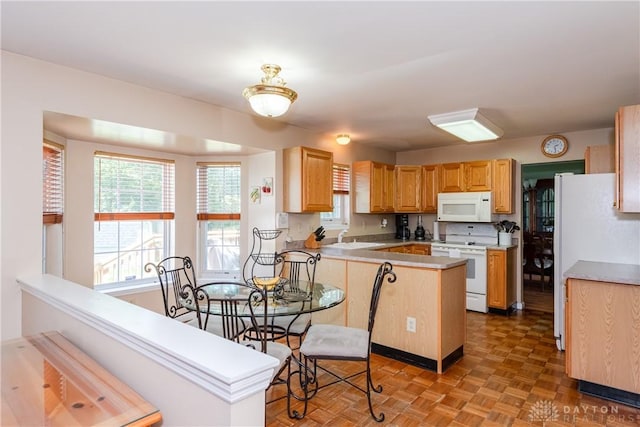 2384 Flyway Ct, Beavercreek, OH 45431 - kitchen featuring white appliances, a peninsula, light brown cabinets, and light countertops