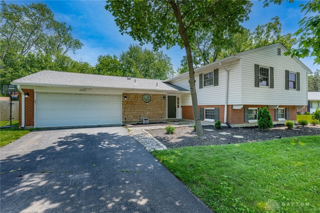 5412 Newell Dr, Kettering, OH 45440 - split level home featuring an attached garage, driveway, and a front lawn