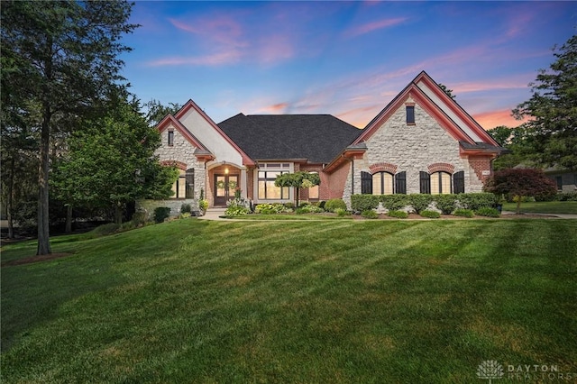 7921 Locust Grove Ct, Springboro, OH 45066 - french country style house with stone siding, a front yard, and french doors