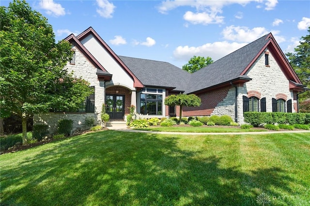 7921 Locust Grove Ct, Springboro, OH 45066 - view of front of property with stone siding, french doors, a front lawn, and a shingled roof