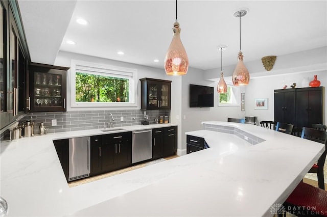 7921 Locust Grove Ct, Springboro, OH 45066 - kitchen featuring stainless steel dishwasher, a kitchen bar, glass insert cabinets, decorative light fixtures, and decorative backsplash