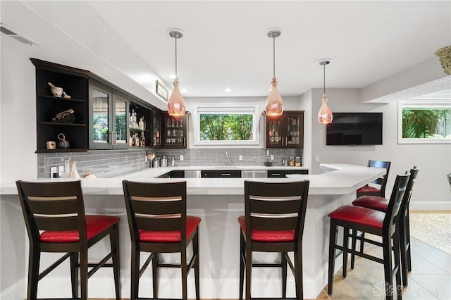 7921 Locust Grove Ct, Springboro, OH 45066 - indoor wet bar with decorative backsplash, healthy amount of natural light, light tile patterned floors, and decorative light fixtures
