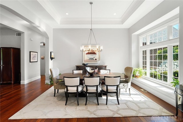 7921 Locust Grove Ct, Springboro, OH 45066 - dining area with a raised ceiling, wood finished floors, a chandelier, crown molding, and arched walkways