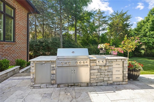7921 Locust Grove Ct, Springboro, OH 45066 - view of patio with an outdoor kitchen and view of wooded area