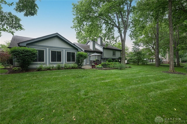 5010 Rhine Way, Centerville, OH 45458 - rear view of property featuring a lawn and a chimney