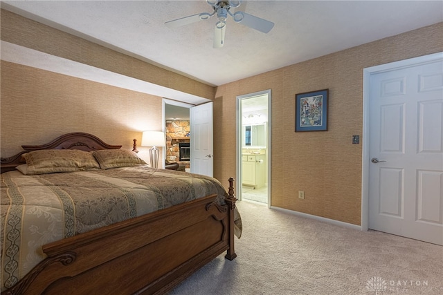 5010 Rhine Way, Centerville, OH 45458 - carpeted bedroom with ensuite bath, a ceiling fan, and a stone fireplace