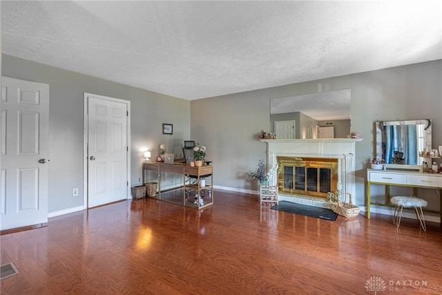 9031 S Normandy Ln, Washington Twp, OH 45458 - living area featuring wood finished floors, a textured ceiling, a desk, and a glass covered fireplace