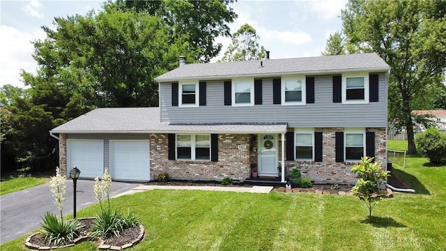 660 N Main St, Union, OH 45322 - view of front of home with an attached garage, asphalt driveway, a front lawn, and brick siding