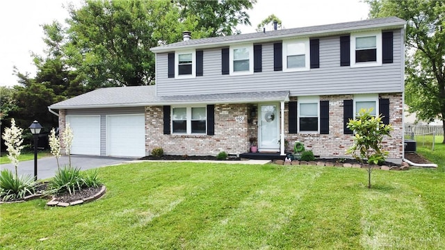 660 N Main St, Union, OH 45322 - view of front of property featuring a garage, concrete driveway, a front yard, and brick siding