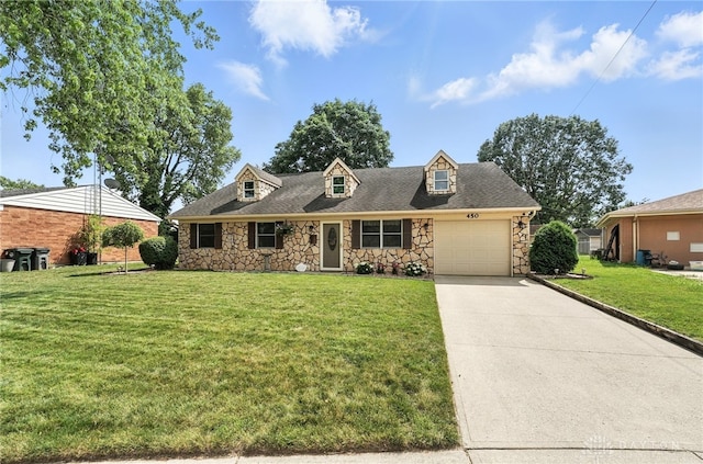 450 Overfield Pl, Troy, OH 45373 - cape cod house featuring stone siding, a front yard, an attached garage, and driveway