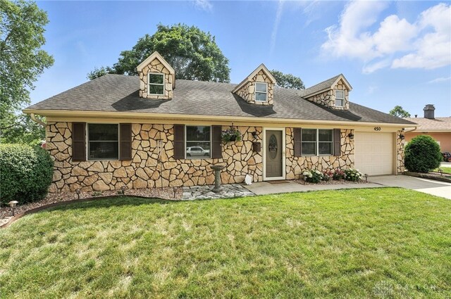 450 Overfield Pl, Troy, OH 45373 - cape cod home featuring stone siding, an attached garage, driveway, and a front yard