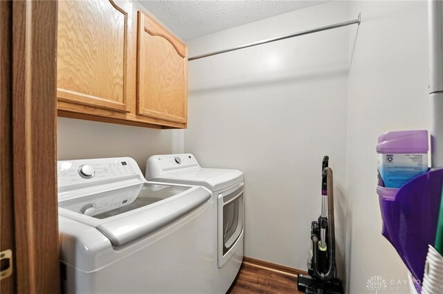 450 Overfield Pl, Troy, OH 45373 - laundry area featuring cabinet space, washing machine and clothes dryer, dark wood-type flooring, and a textured ceiling