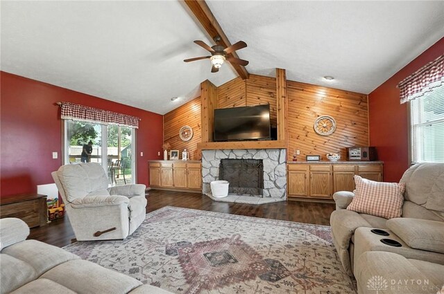 450 Overfield Pl, Troy, OH 45373 - living area with an accent wall, wooden walls, a ceiling fan, a stone fireplace, and dark wood-style floors