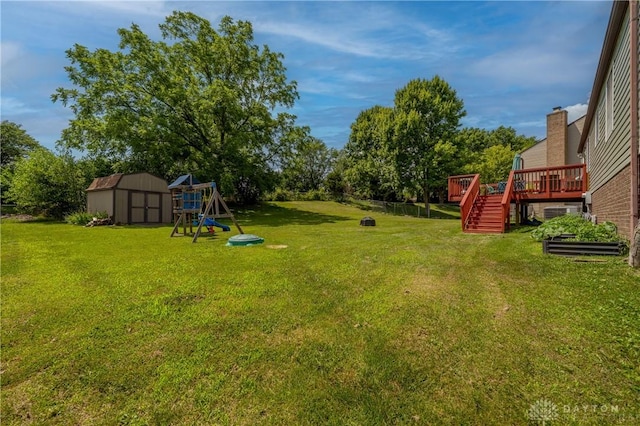 4913 Bittern Ct, Huber Heights, OH 45424 - view of green lawn with a shed, a wooden deck, stairs, and a playground