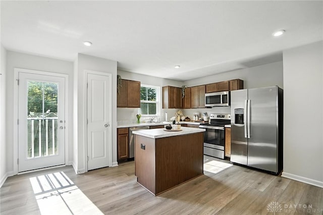 55 Spicewood Dr, Amelia, OH 45102 - kitchen with appliances with stainless steel finishes, a center island, light wood finished floors, light countertops, and dark brown cabinets
