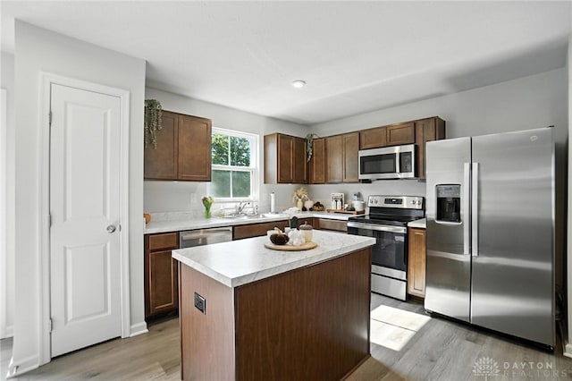 55 Spicewood Dr, Amelia, OH 45102 - kitchen with stainless steel appliances, light wood finished floors, light countertops, a center island, and dark brown cabinets