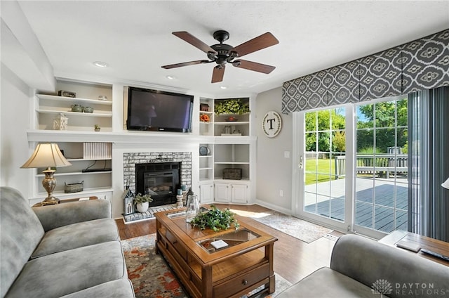 3166 Green Turtle Dr, Butler Twp, OH 45414 - living room featuring wood finished floors, ceiling fan, a brick fireplace, and built in shelves