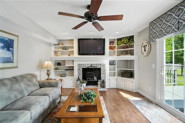 3166 Green Turtle Dr, Butler Twp, OH 45414 - living area featuring wood finished floors, a ceiling fan, a fireplace, built in shelves, and recessed lighting