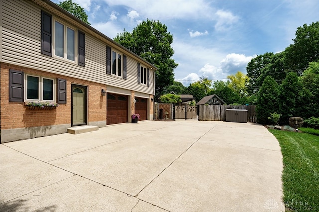 5516 Anne Ln, Washington Twp, OH 45459 - view of home's exterior with concrete driveway, an attached garage, brick siding, and a gate