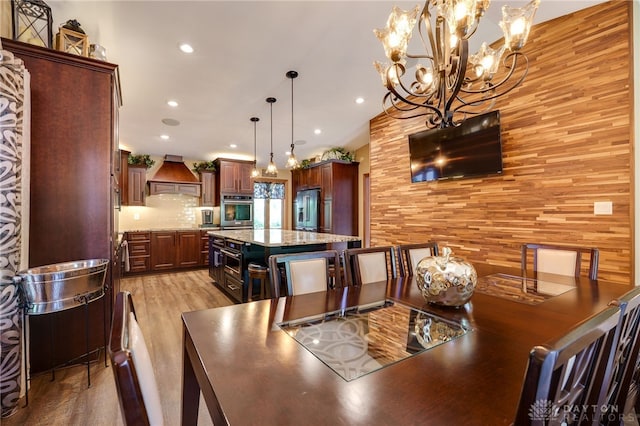 5516 Anne Ln, Washington Twp, OH 45459 - dining space featuring light wood-style flooring, a chandelier, recessed lighting, and wood walls