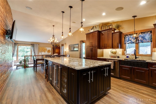 5516 Anne Ln, Washington Twp, OH 45459 - kitchen with stainless steel dishwasher, light wood finished floors, a chandelier, decorative light fixtures, and light stone countertops