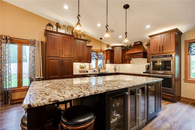5516 Anne Ln, Washington Twp, OH 45459 - kitchen featuring double oven, custom exhaust hood, beverage cooler, dark wood-type flooring, and recessed lighting