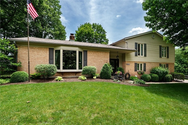 5516 Anne Ln, Washington Twp, OH 45459 - split level home featuring brick siding, a front lawn, and a chimney