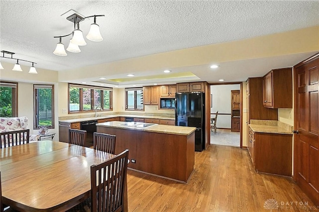 1101 Fox Chase Ct, Centerville, OH 45459 - kitchen with black appliances, a center island, light wood-style flooring, a textured ceiling, and light countertops