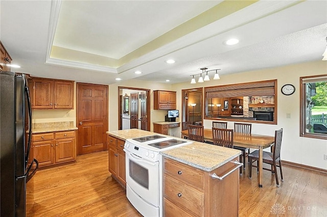 1101 Fox Chase Ct, Centerville, OH 45459 - kitchen featuring freestanding refrigerator, electric range, a center island, light wood-type flooring, and brown cabinetry