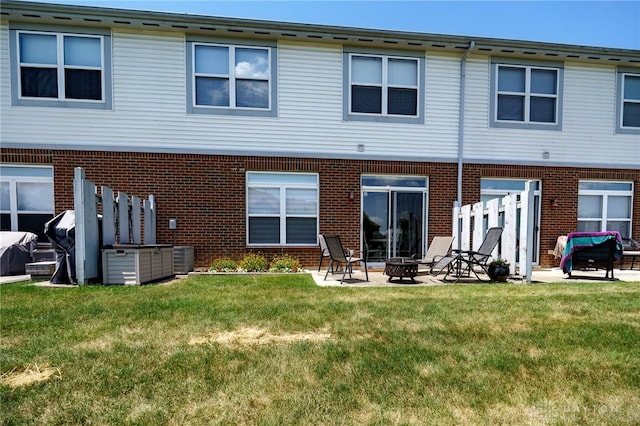 9270 Great Lakes Cir Unit 9270, Washington Twp, OH 45458 - back of house featuring a fire pit, a patio, brick siding, and a lawn