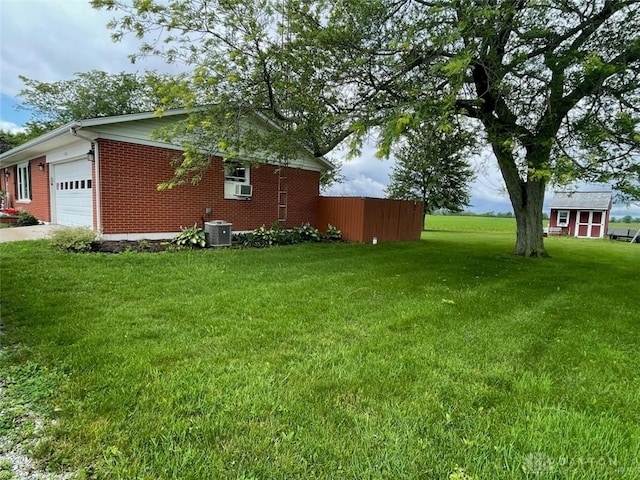 8320 N State Route 589, Fletcher, OH 45326 - view of grassy yard with a garage, cooling unit, and concrete driveway