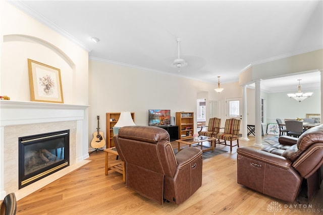 2396 Vienna Pkwy, Dayton, OH 45459 - living area featuring crown molding, light wood finished floors, a fireplace, a chandelier, and decorative columns