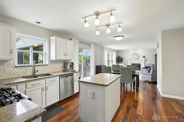 6630 Falling Leaves Ct, Mason, OH 45040 - kitchen with dishwasher, a glass covered fireplace, white cabinetry, tasteful backsplash, and a kitchen island