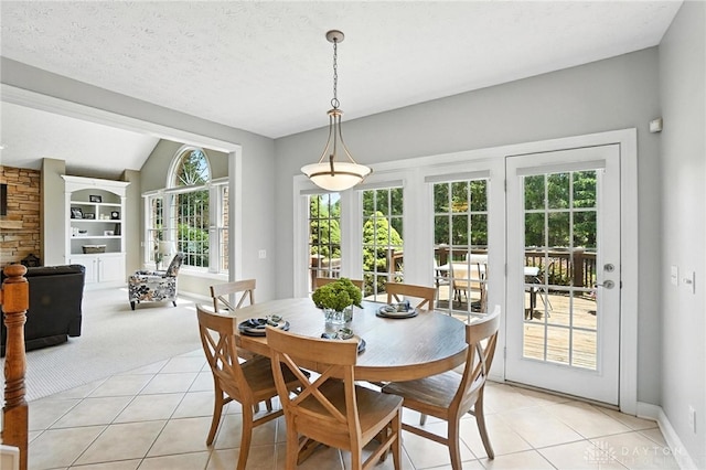 10598 Falls Creek Ln, Washington Twp, OH 45458 - dining space with light tile patterned floors, vaulted ceiling, light colored carpet, and a fireplace
