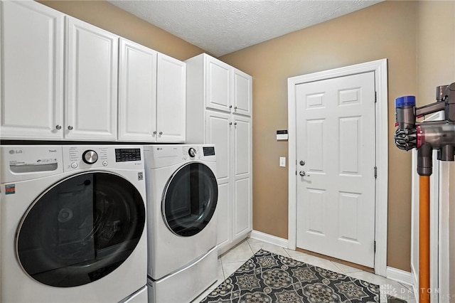 10598 Falls Creek Ln, Washington Twp, OH 45458 - washroom featuring cabinet space, washer and dryer, light tile patterned floors, and a textured ceiling