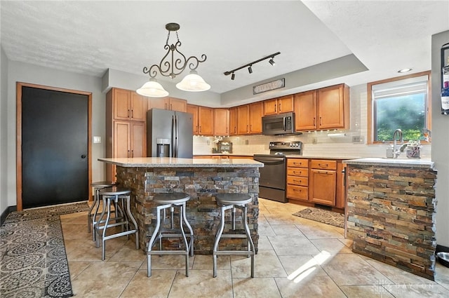 1778 Kensington Dr, Bellbrook, OH 45305 - kitchen featuring stainless steel appliances, backsplash, a kitchen island, a kitchen breakfast bar, and hanging light fixtures