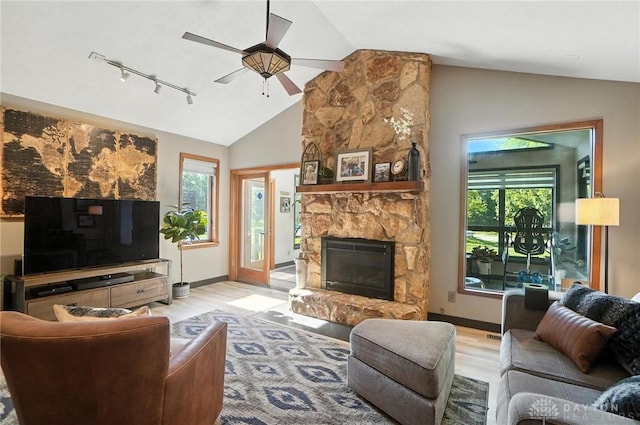 1778 Kensington Dr, Bellbrook, OH 45305 - living room with lofted ceiling, wood finished floors, a ceiling fan, rail lighting, and a stone fireplace