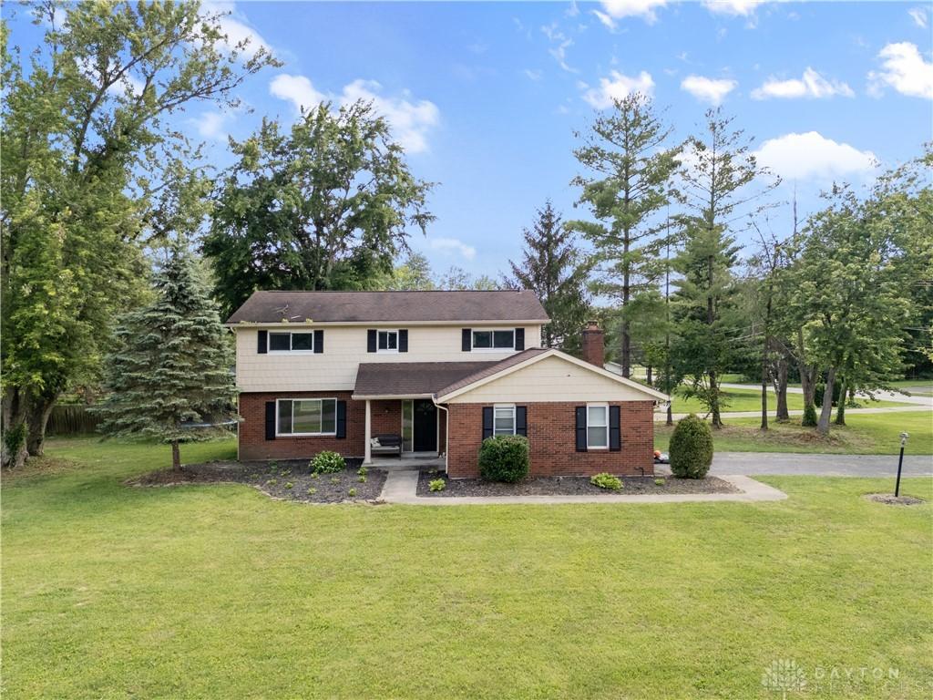 6618 Paxton Guinea Rd, Miami Twp, OH 45140 - traditional-style home with covered porch, brick siding, and a front yard