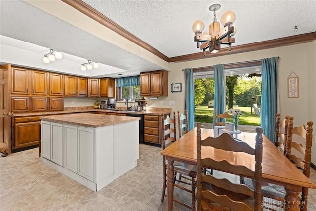 4981 Old Mill Rd, Oh, OH 45502 - kitchen with brown cabinets, a chandelier, a textured ceiling, ornamental molding, and light countertops
