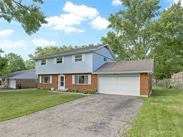 6118 Carnation Rd, Dayton, OH 45449 - colonial home featuring asphalt driveway, an attached garage, and brick siding