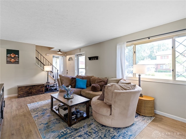 6118 Carnation Rd, Dayton, OH 45449 - living room featuring wood finished floors, stairway, and a textured ceiling