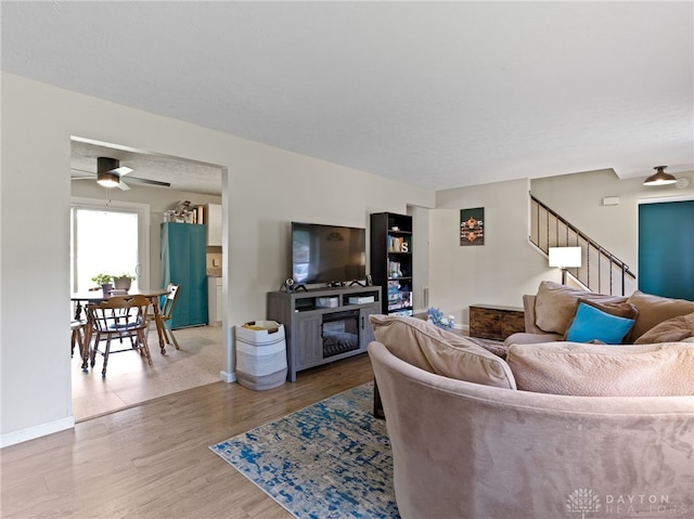 6118 Carnation Rd, Dayton, OH 45449 - living area with wood finished floors, stairway, a ceiling fan, and a fireplace