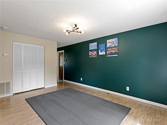 6118 Carnation Rd, Dayton, OH 45449 - unfurnished bedroom featuring a chandelier, wood finished floors, and a closet